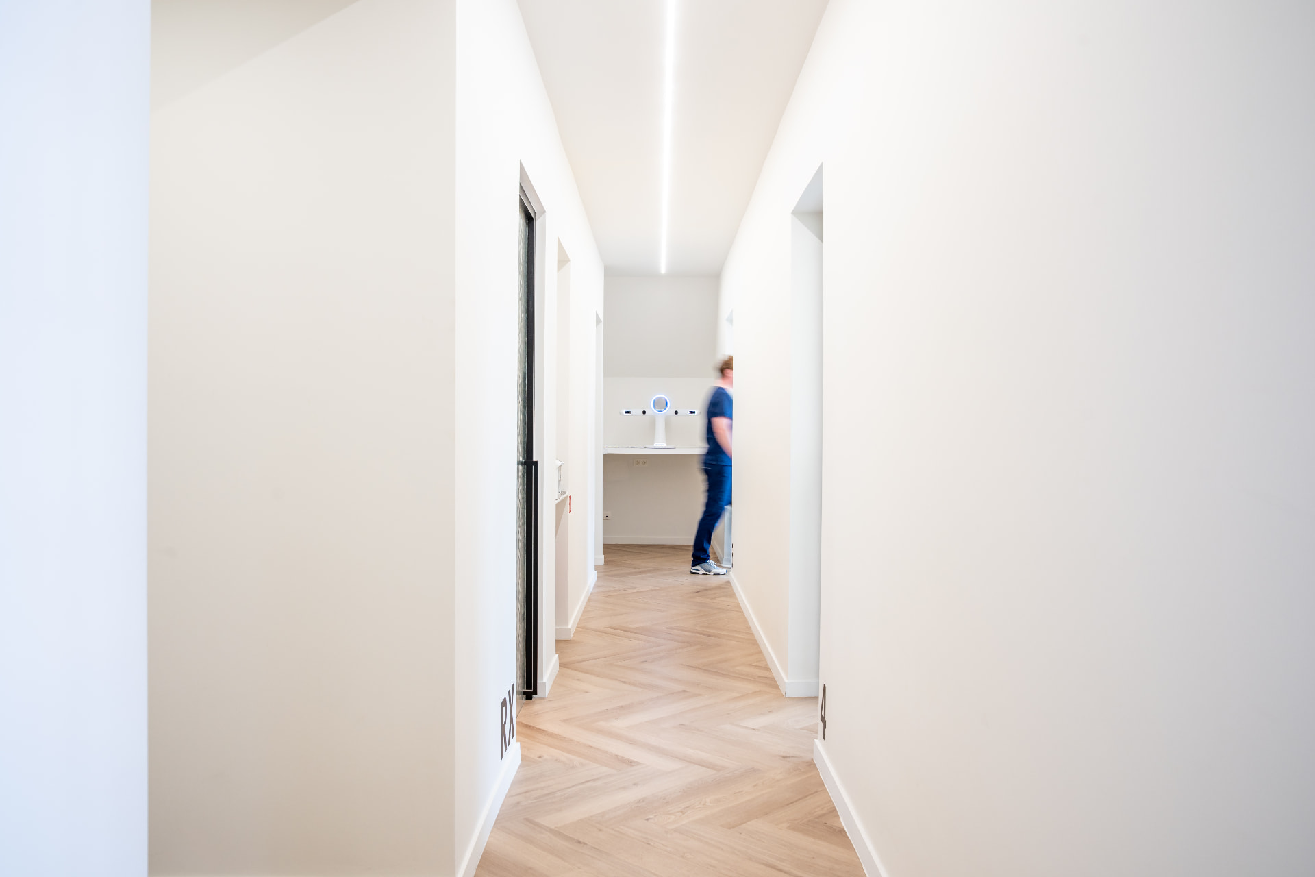 Lichte gang met parketvloer naar de behandelkamers